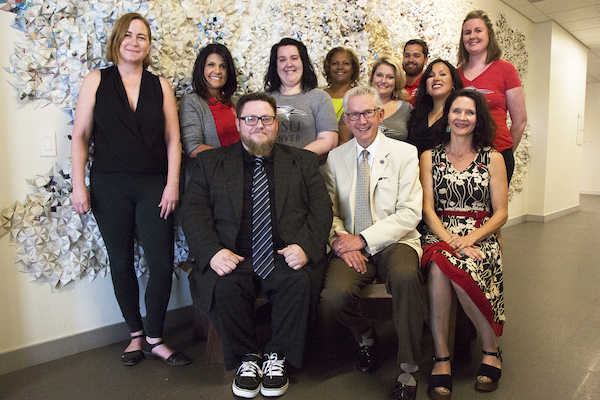 Industrial design student Benjamin Booker’s (sitting on bench, left) winning custom bench, was dedicated to Dr. Stephen M. Jordan (center), MSU Denver’s president, who will retire June 30. Seated on the bench, right, is Lunden MacDonald, director of the University’s First Year Success program, which sponsored the bench design contest, joined by faculty Amy Kern and FYS staff.