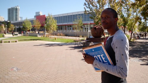 Person holding a register to vote binder in-front of Auraria Library