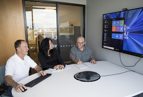 People sitting in conference room looking at computer