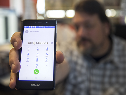 Man holding cell phone up to screen