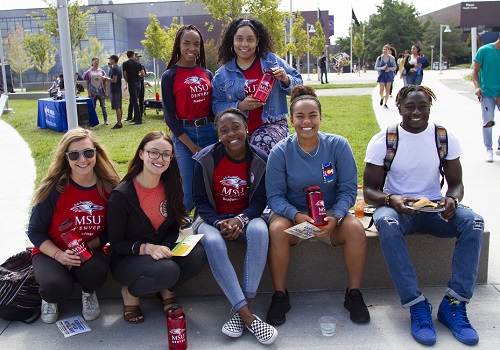 students sitting together outside and wearing MSU Denver attire.