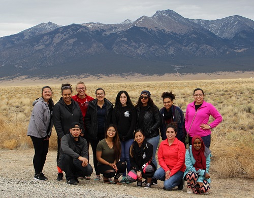 Students standing in a group in front of a mountain range