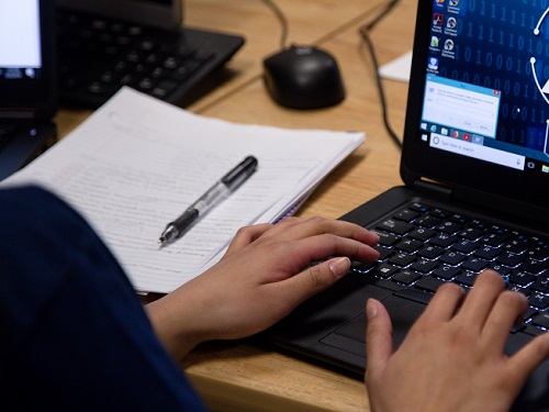 hands hovering above computer keyboard