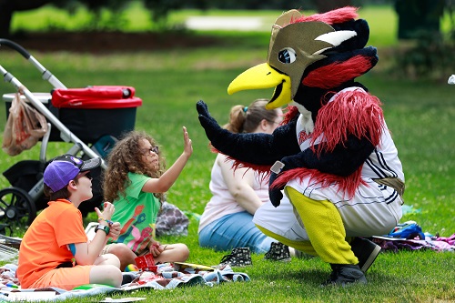 Rowdy the Roadrunner high-fiving a child