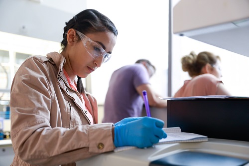 Student in biology lab writing paper