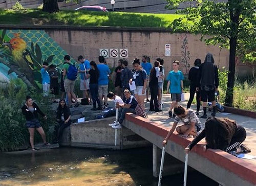 Students in STEM camp testing water in Cherry Creek.