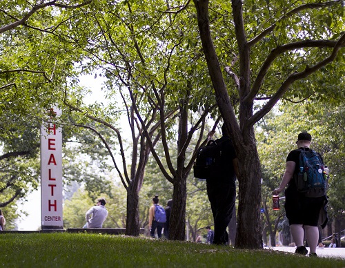 Trees in summer with Health Center sign in background