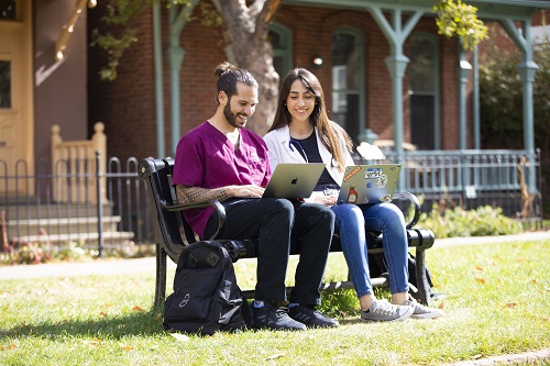 Students sitting on a bench in Ninth Street Park.