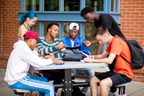 Students sitting together at a picnic table.