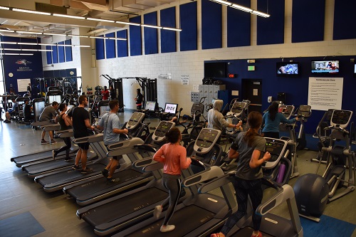 People exercising on equipment in the Auraria Campus fitness center.